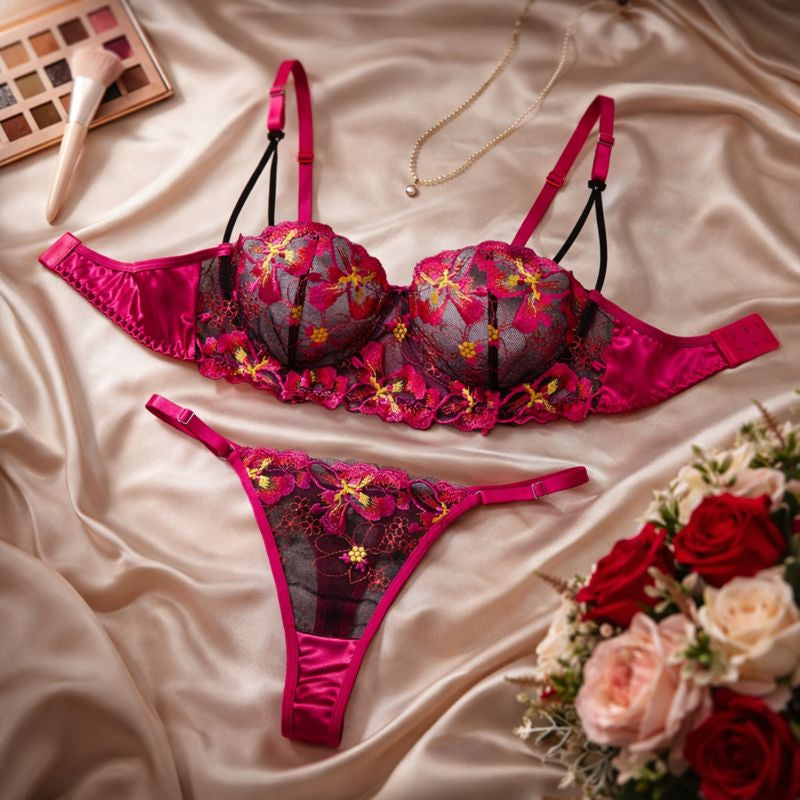 Lyvra Luxus Dessous Set in Magenta und Schwarz aus feiner Spitze, BH in Rückansicht mit Satinband und passendem String auf edlem Hintergrund